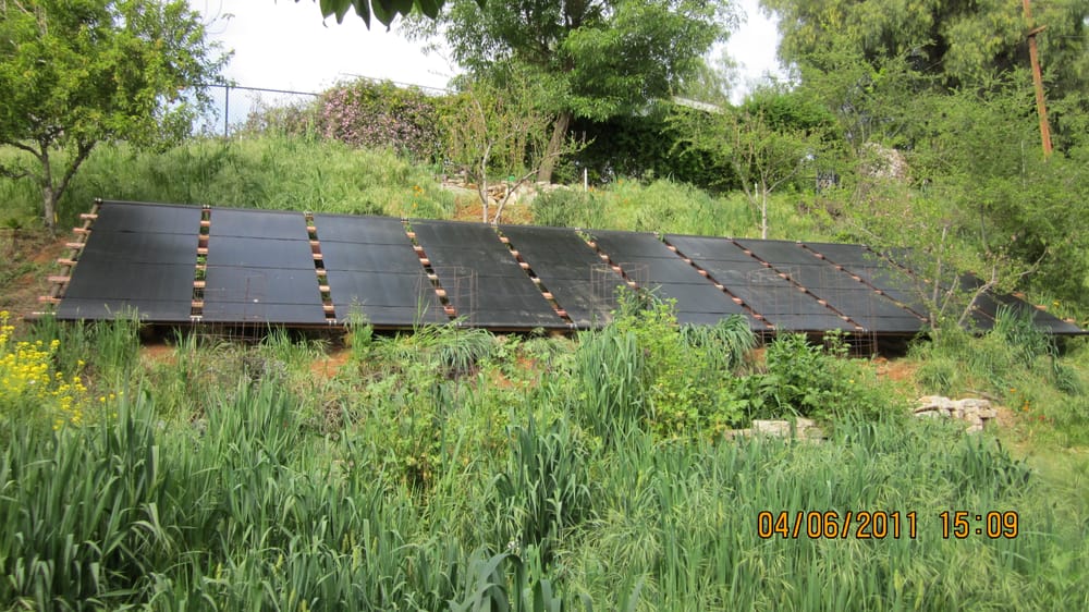 A slope-mounted solar collector array set into landscaped grounds