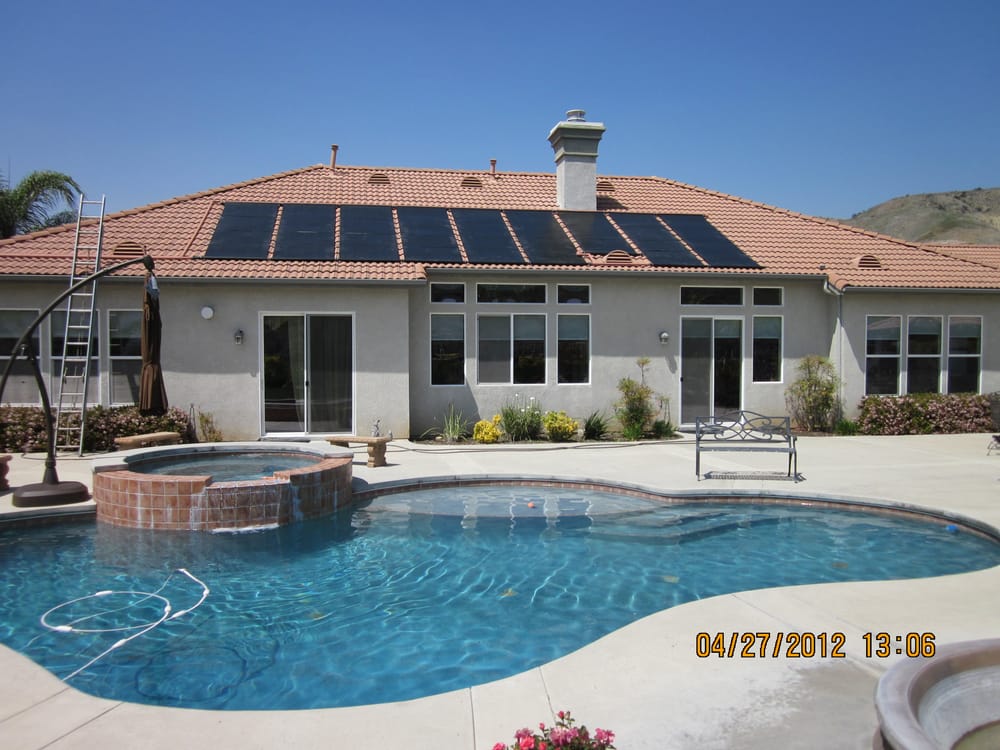 Backyard pool and spa heated by a rooftop solar collector array