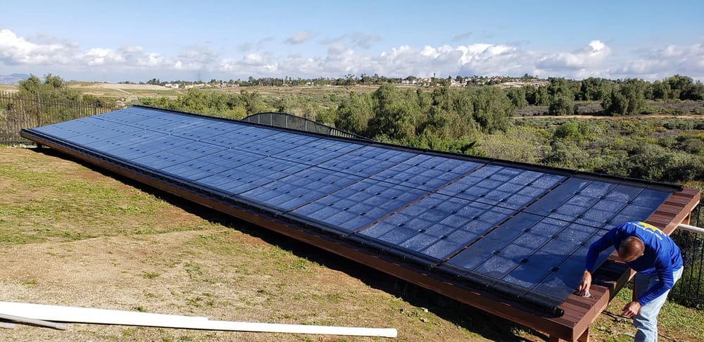 A full rooftop solar pool heating collector array overlooking a valley