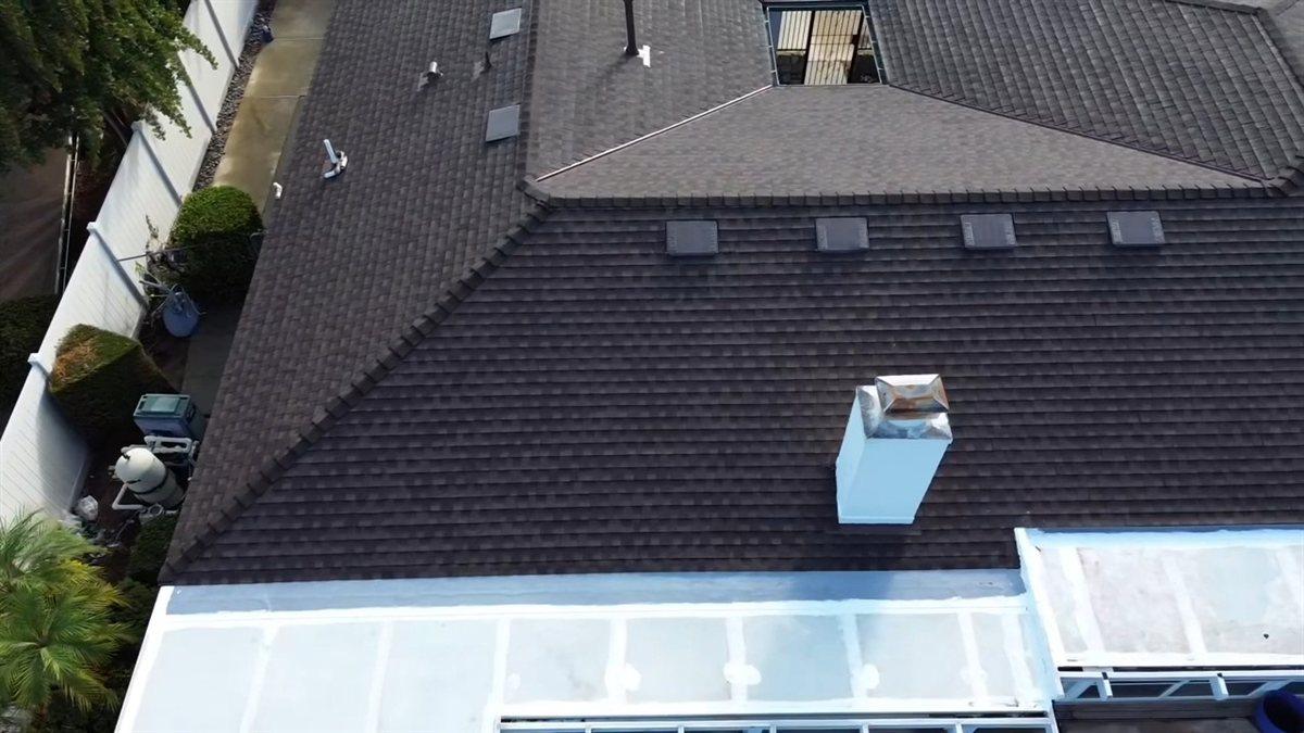 Aerial view of a brown shingle roof before installation, with no solar collectors and the pool equipment already in the side yard