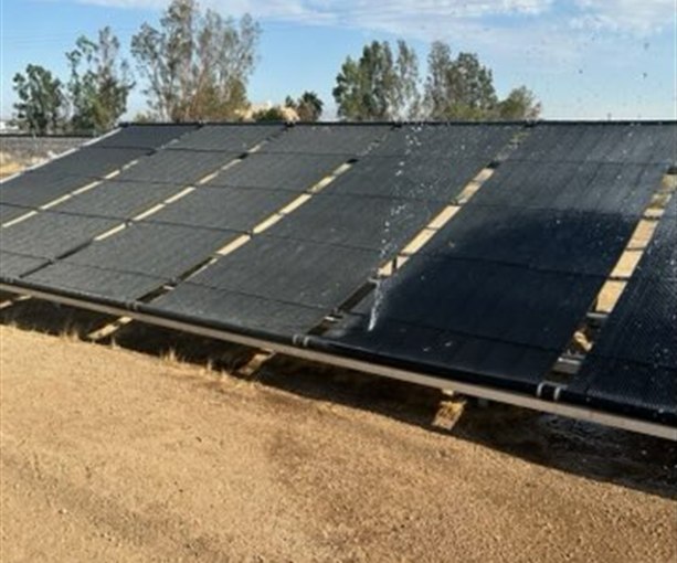 Water spraying from a leak in a ground-mounted solar pool heating array